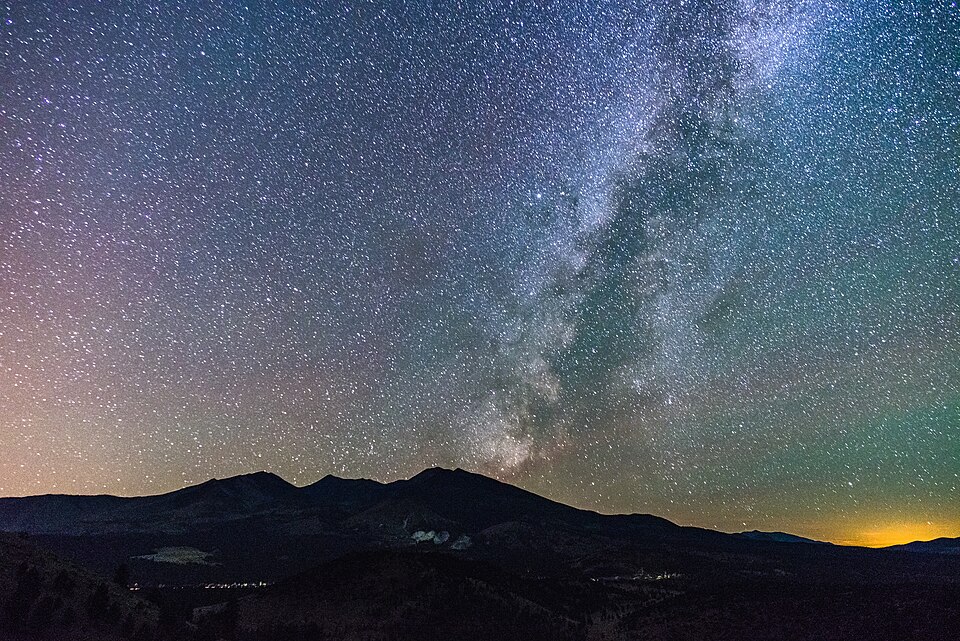 Die Milchstraße und viele Sterne über der dunklen Bergsilhouette der San Francisco Peaks.